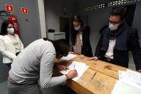 equipe da defensoria em pé atras da mesa, ppl assinando documento