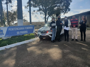 Foto de servidores recebendo o veículo em frente a unidade penal